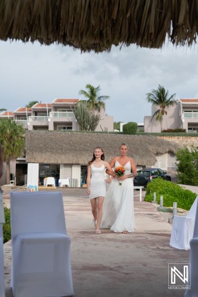 Couple walks down the aisle at a beautiful wedding ceremony in Curacao with tropical scenery and floral arrangements