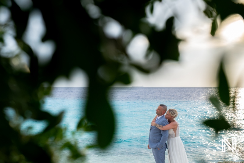 Couple embraces by the turquoise waters of Curacao during a romantic wedding ceremony at Karakter restaurant