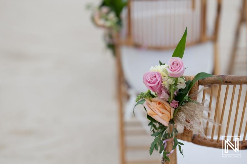 Beautiful floral arrangements decorate chairs for a romantic wedding ceremony in Sunscape Curacao on the beach