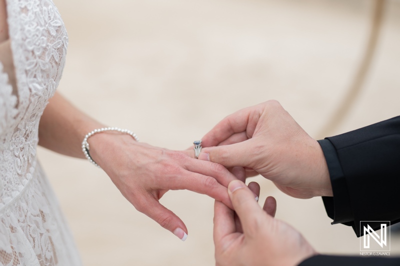 Couple exchanges wedding rings during a destination ceremony at Sunscape Curacao beach location in beautiful tropical setting