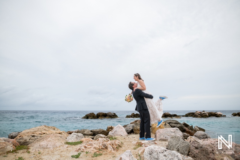 Couple celebrates their destination wedding at Sunscape Curacao, surrounded by beautiful beach and rocky landscape