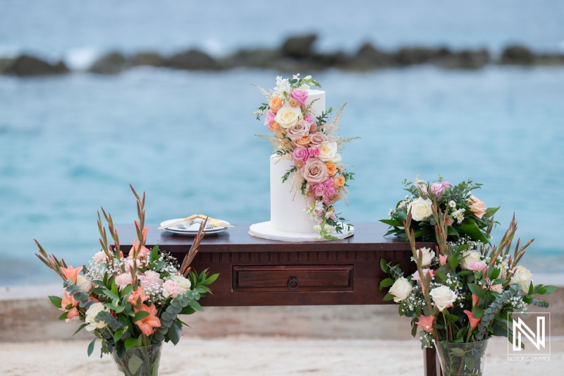 Beautiful wedding cake display with floral decorations at Sunscape Curacao destination wedding celebration by the sea
