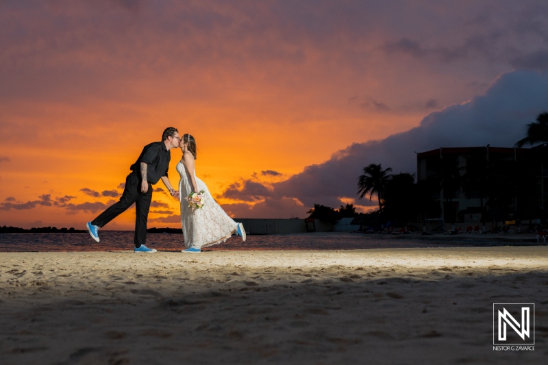 Couple shares a romantic kiss during their sunset wedding at Sunscape Curacao beach