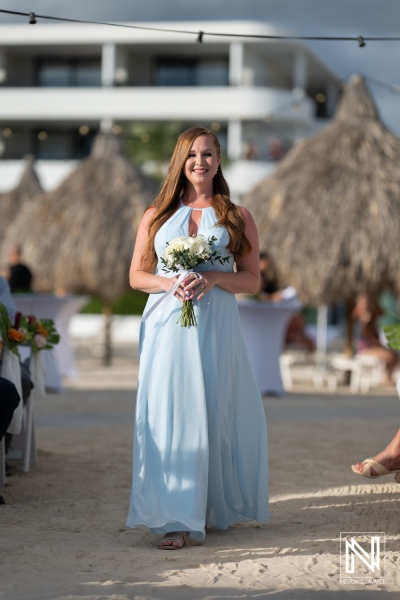 Bride's maid gracefully walks down sandy aisle at wedding ceremony in Curacao at the Rif at Mangrove Beach Corendon