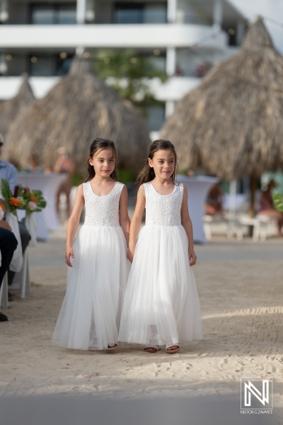 Girls in white dress walk down the beach aisle during a wedding ceremony at Mangrove Beach in Curacao