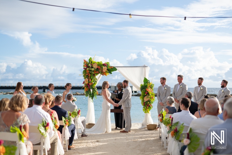 Couples exchange vows during a beautiful wedding ceremony at Mangrove Beach in Curacao on a sunny day with a picturesque backdrop