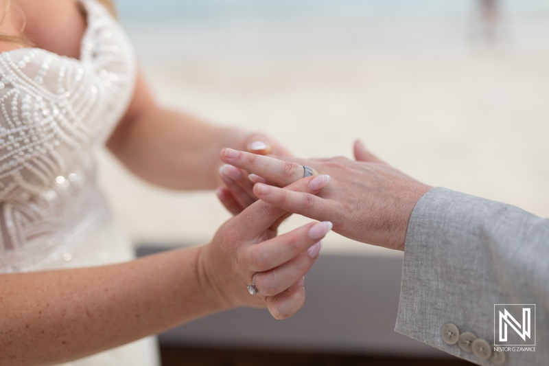 Couple exchanges wedding rings during a romantic ceremony at Mangrove Beach in Curacao, celebrating their love in a beautiful tropical setting