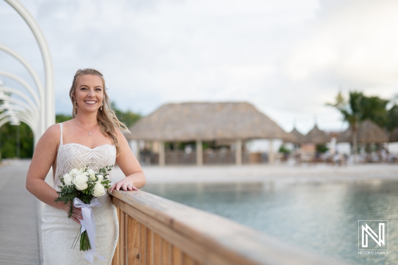 Wedding celebration at Mangrove Beach Corendon in Curacao with stunning bride holding bouquet near waterfront