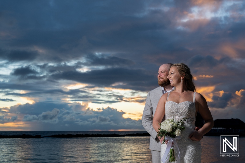 Wedding celebration during sunset at Rif at Mangrove Beach in Curacao, featuring a happy couple embracing the moment