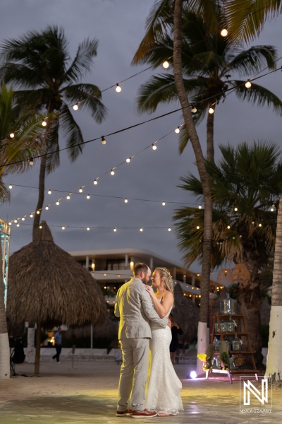Couple celebrating their wedding under string lights at Mangrove Beach in Curacao during a romantic evening