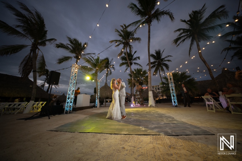 Magical wedding celebration at Mangrove Beach in Curacao under twinkling lights and palm trees during sunset