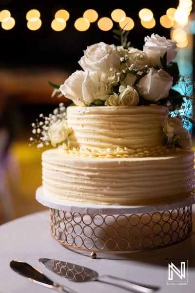 Elegant wedding cake adorned with white roses at a celebration in Curacao near the Rif at Mangrove Beach Corendon