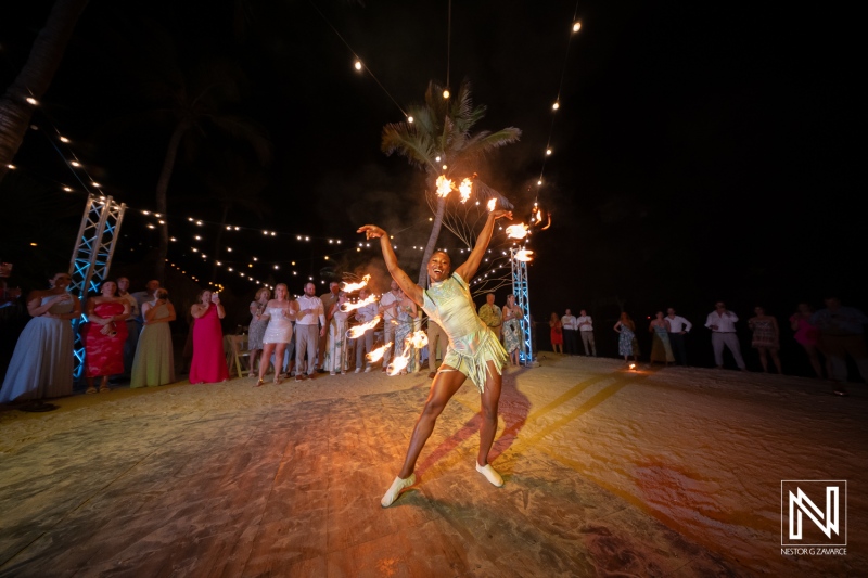 Dancer performs with fire at wedding celebration in Curacao, enchanting guests at The Rif at Mangrove Beach Corendon during an unforgettable evening