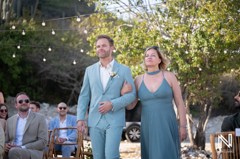 Wedding celebration at Playa Hunku in Curacao on a sunny day with guests seated and couple preparing to walk down the aisle