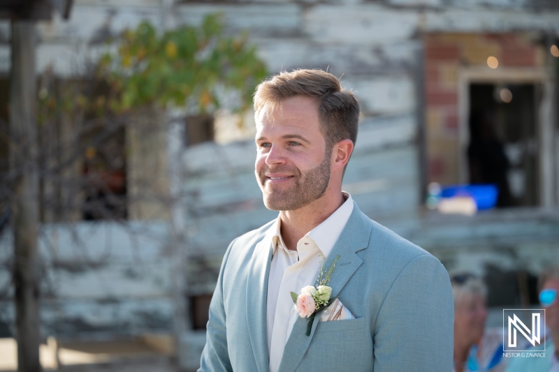Wedding at Playa Hunku in Curacao during bright and sunny day with groom smiling as guests gather