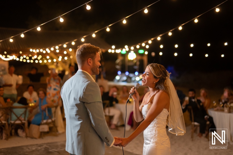 Wedding ceremony at Playa Hunku in Curacao with couple sharing vows under string lights