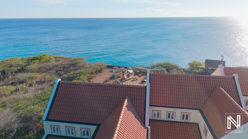 Wedding ceremony taking place by the ocean in Westpunt Curacao during sunny weather with guests enjoying the moment