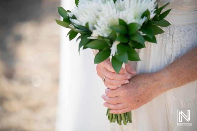Wedding ceremony in Westpunt Curacao with a bride holding a bouquet of flowers