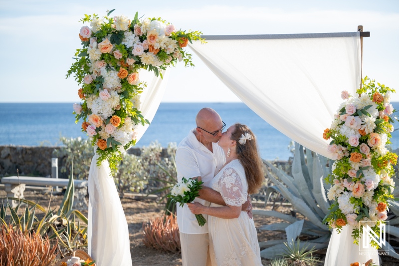 Couple kisses during their wedding ceremony by the ocean in Westpunt Curacao