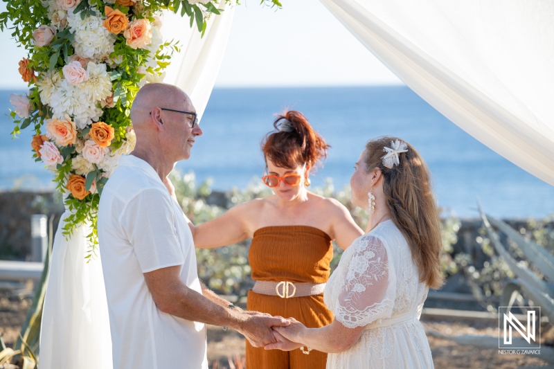 Wedding ceremony taking place at Westpunt Curacao with couple exchanging vows by the ocean