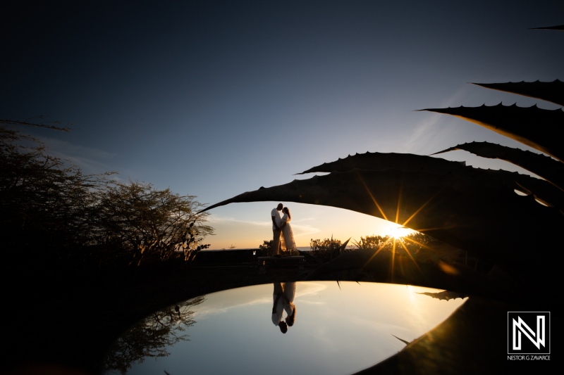 Couple shares a moment during their wedding ceremony in Westpunt Curacao at sunset with reflection in water
