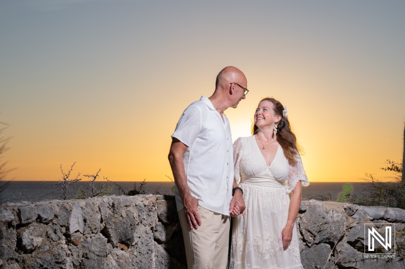 Couple celebrates wedding ceremony in Westpunt Curacao during sunset with a beautiful ocean view in the background