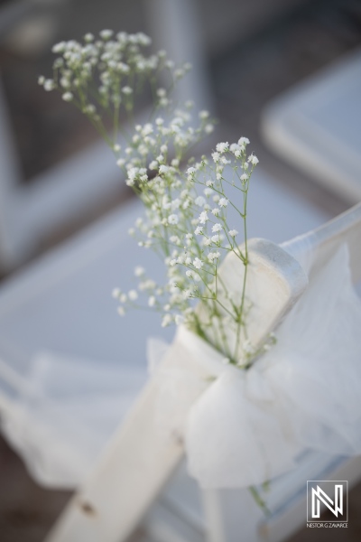 Flowers tied to a chair at a wedding at Karakter in Curacao during a sunny day