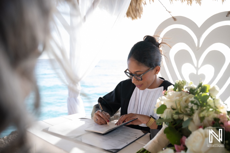 Couple signs wedding documents at Karakter in Curacao during a beach ceremony