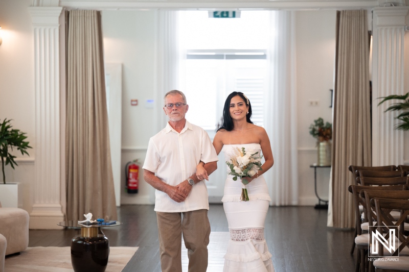 Ceremony at Avila Beach Hotel in Curacao with bride and father walking together