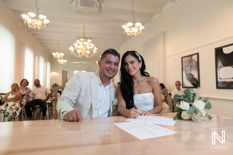 Couple signs marriage paperwork at wedding ceremony at Avila Beach Hotel in Curacao