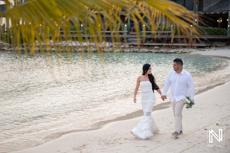 Couple walks hand in hand on the beach at Avila Beach Hotel after their wedding ceremony in Curacao