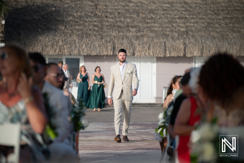 Groom walking down the aisle at a beach wedding in Curacao at Karakter with guests seated on both sides