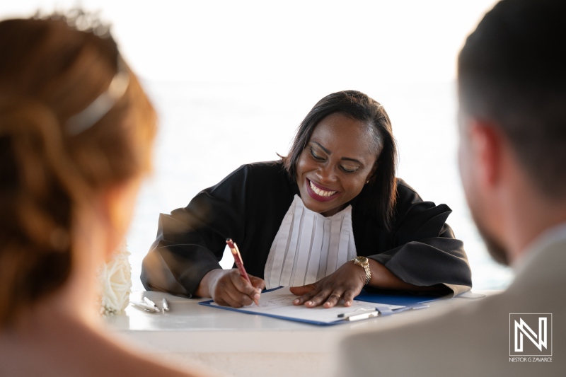 Wedding ceremony at Karakter in Curacao featuring a joyful officiant signing documents