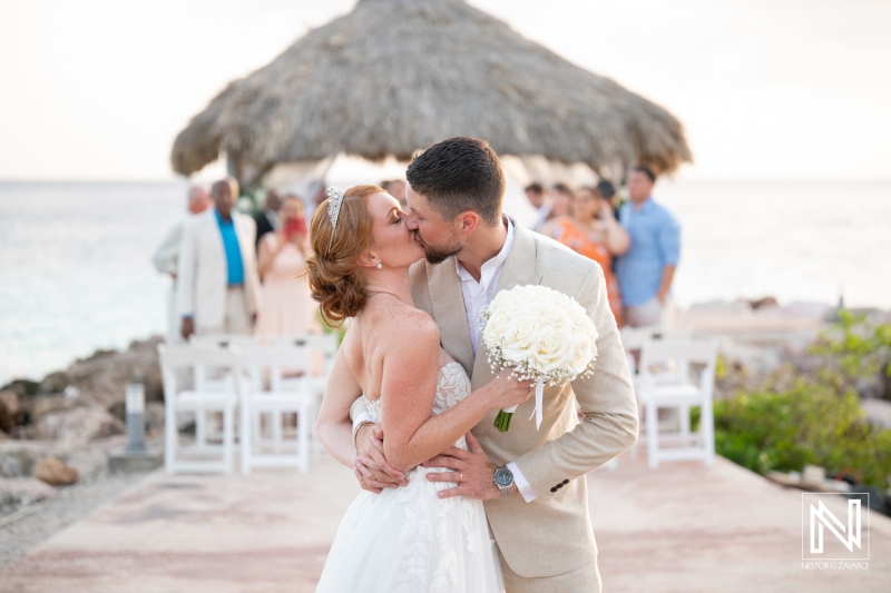 Beautiful wedding ceremony at Karakter in Curacao with a couple sharing a romantic kiss by the ocean