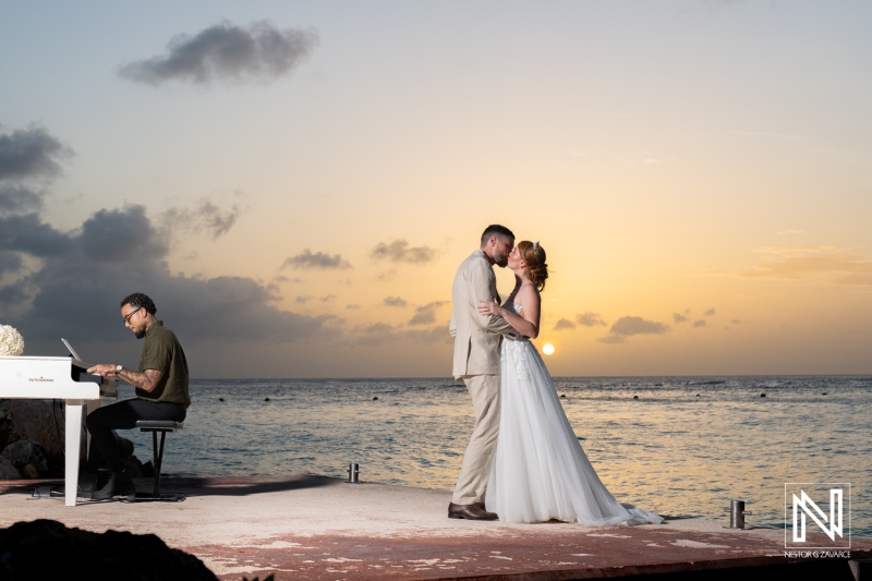 Couple shares a romantic kiss during sunset wedding ceremony at Karakter in Curacao