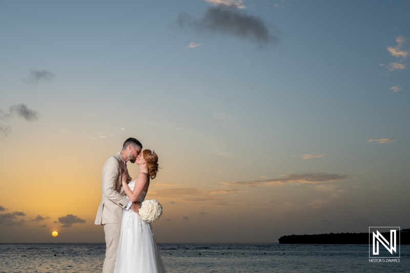 Couple shares a romantic kiss during a sunset wedding at Karakter in Curacao