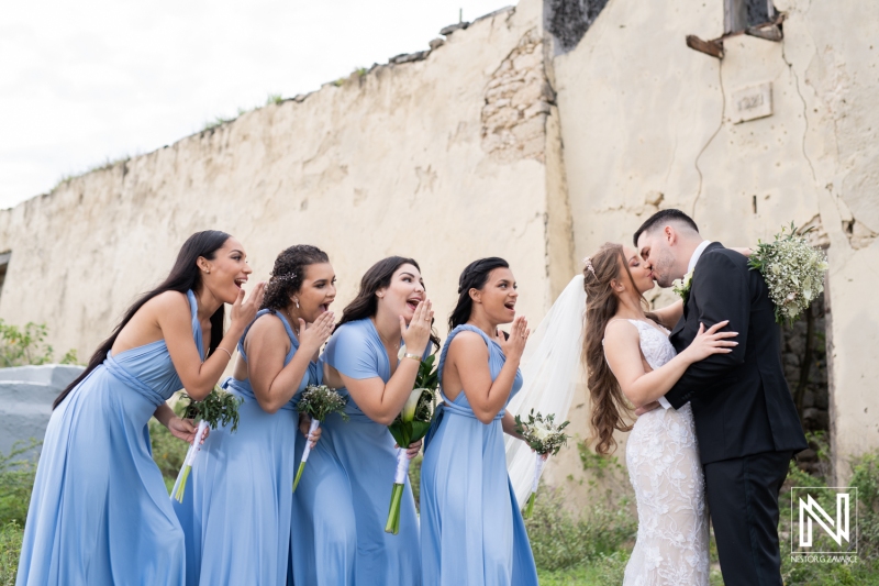 Couple's kiss with bridesmaids
