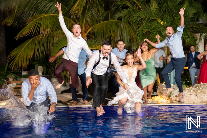 Bridal party jumping at the pool
