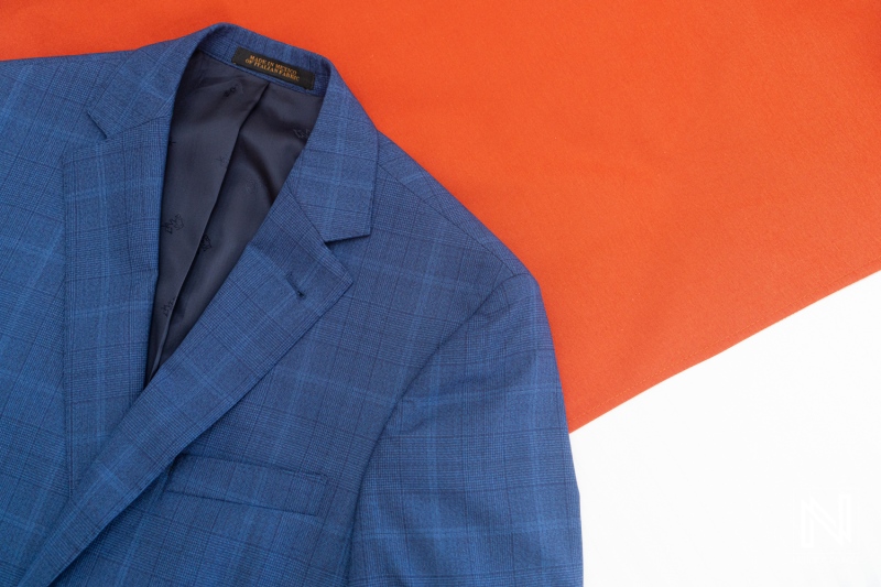 Details of a blue suit jacket resting on a red and white background at a wedding event in Curacao