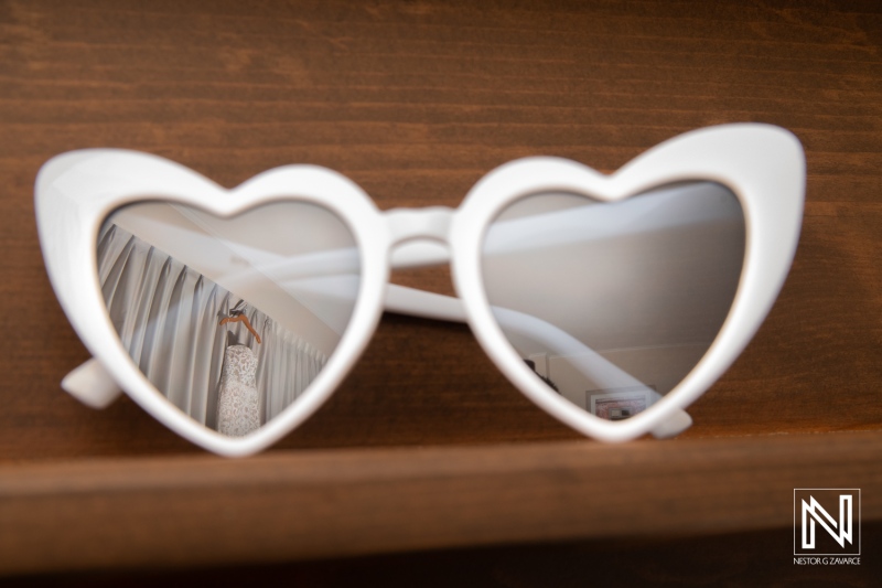 Couple prepares for wedding at Dreams Curaçao Resort with fun heart-shaped sunglasses