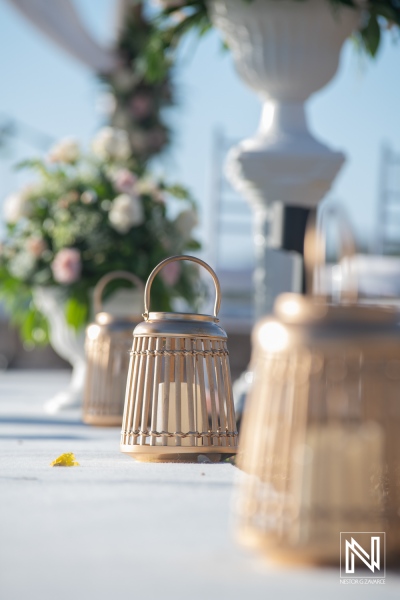 Wedding setup with lanterns and floral arrangements at Dreams Curacao Resort during a sunny day