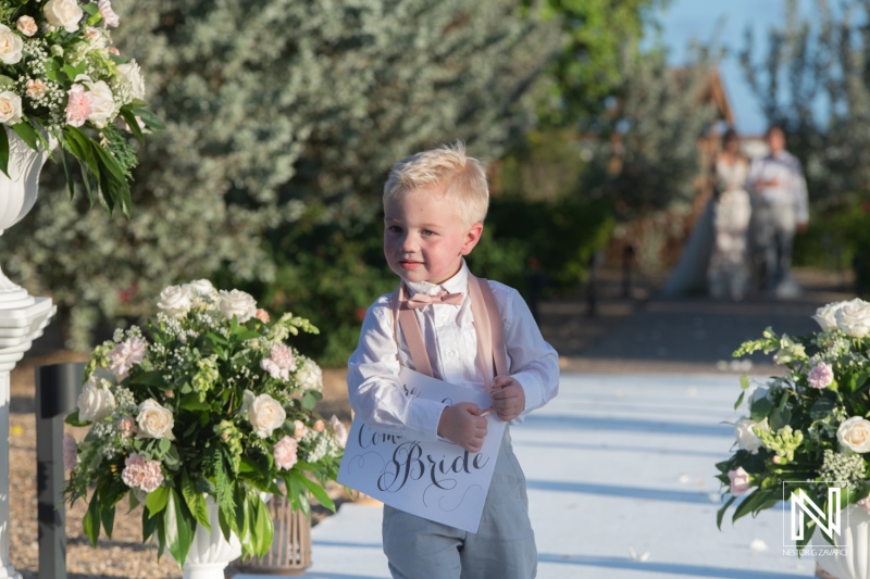 Wedding ceremony at Dreams Curacao Resort with a young boy carrying a sign