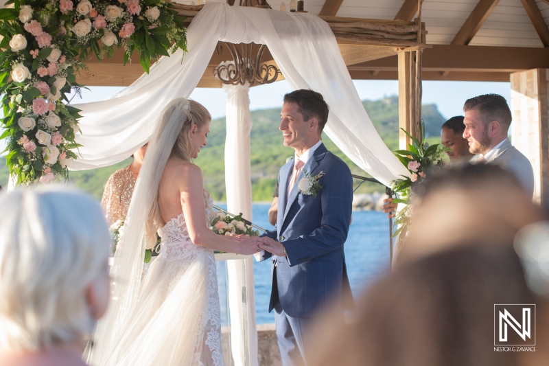 Wedding ceremony at Dreams Curacao Resort by the sea with a beautiful backdrop and guests in attendance