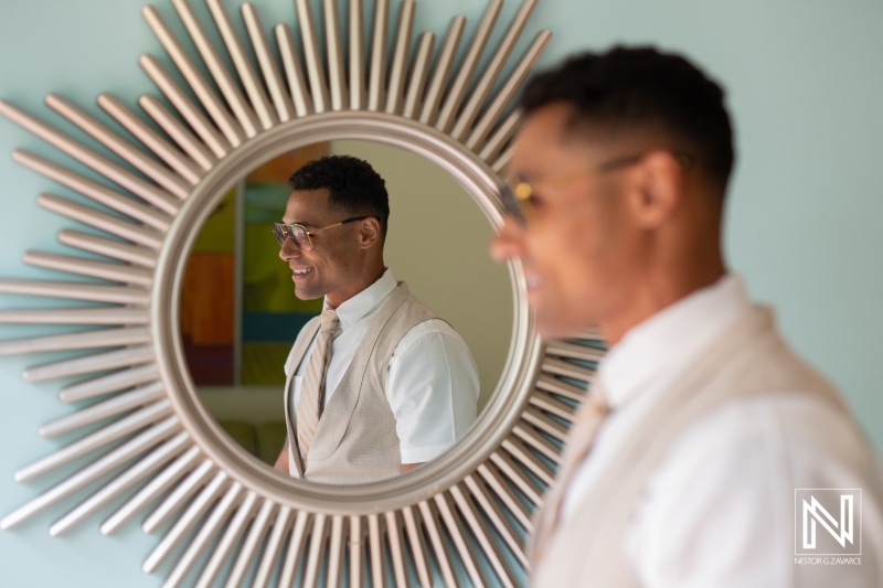 Groom getting ready for a wedding at Sunscape Curacao Resort, reflecting happiness in the mirror before the ceremony