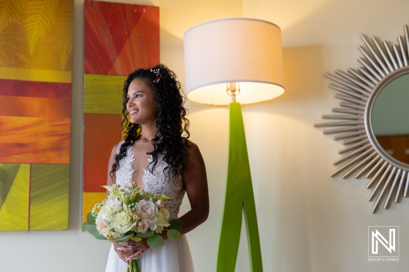 Stunning bride poses with bouquet in vibrant setting at Sunscape Curacao Resort during wedding preparations