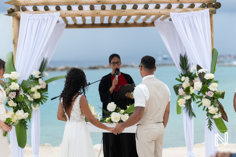 Wedding ceremony at Sunscape Curacao Resort by the beach with beautiful floral decorations and an officiant