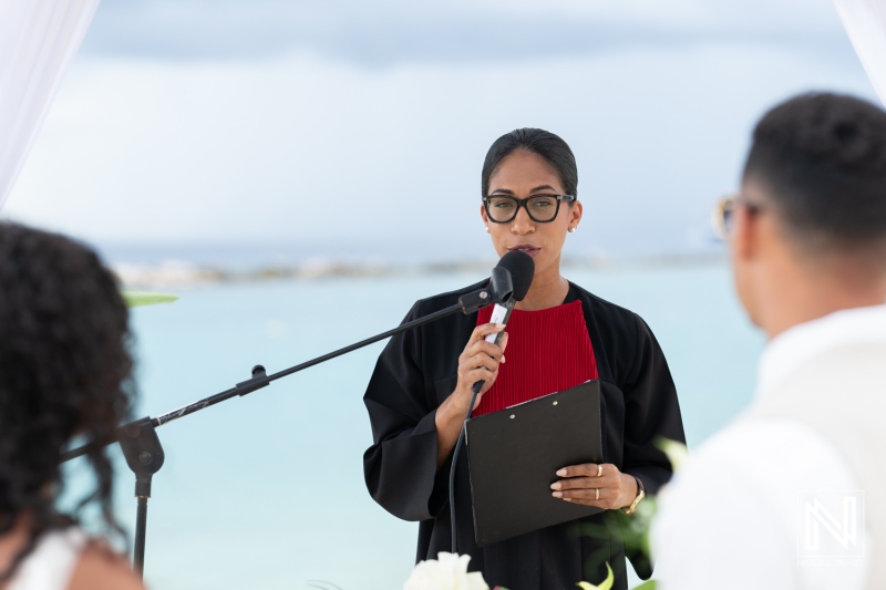 Wedding ceremony taking place at Sunscape Curacao Resort with officiant addressing the couple against a backdrop of blue waters