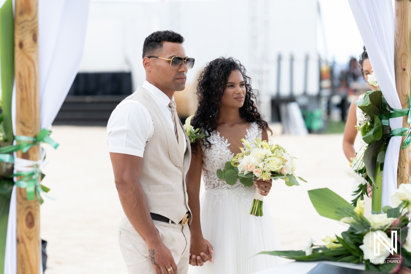 Couple exchanges vows during a romantic wedding ceremony at Sunscape Curaçao Resort in the sunset glow