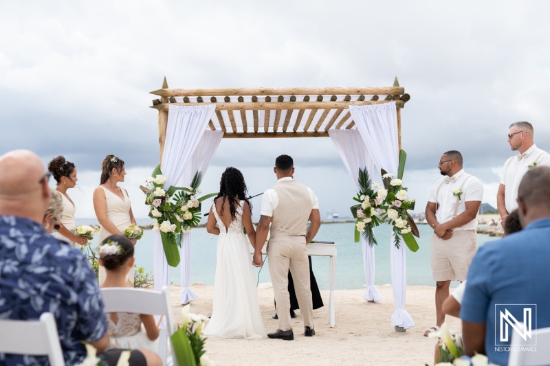 Wedding ceremony at Sunscape Curacao Resort featuring couples exchanging vows by the beach under an elegant altar amidst tropical decor