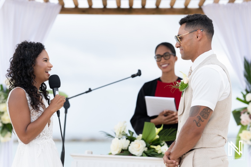 Couple exchanges vows during a beautiful wedding ceremony at Sunscape Curacao Resort by the seaside under a wooden arbor